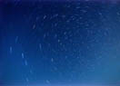 Time exposure of stars above a Lake Michigan beach.